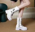 A pair of women's black mid-calf knight boots with a side zip and a large metal buckle strap.