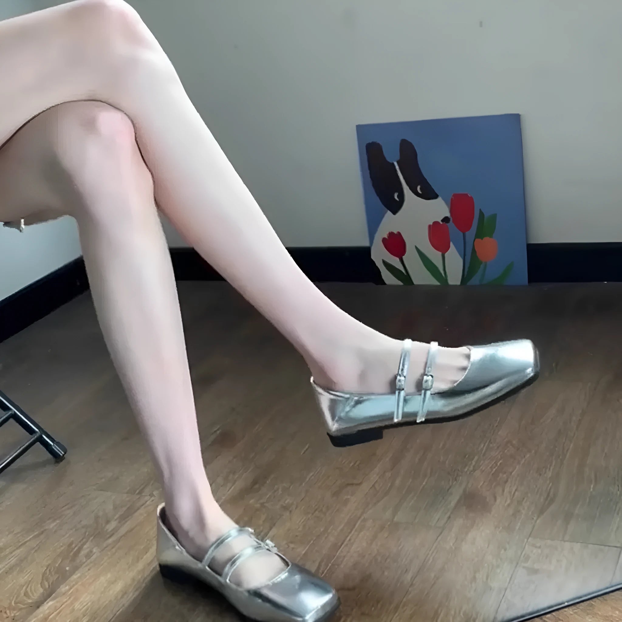 Silver women's leather Mary Jane flats with a cross buckle strap and round toe.