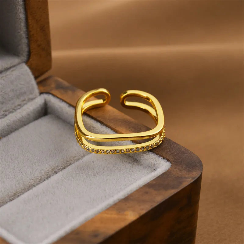 Women's gold geometric open band fashion ring on a hand.