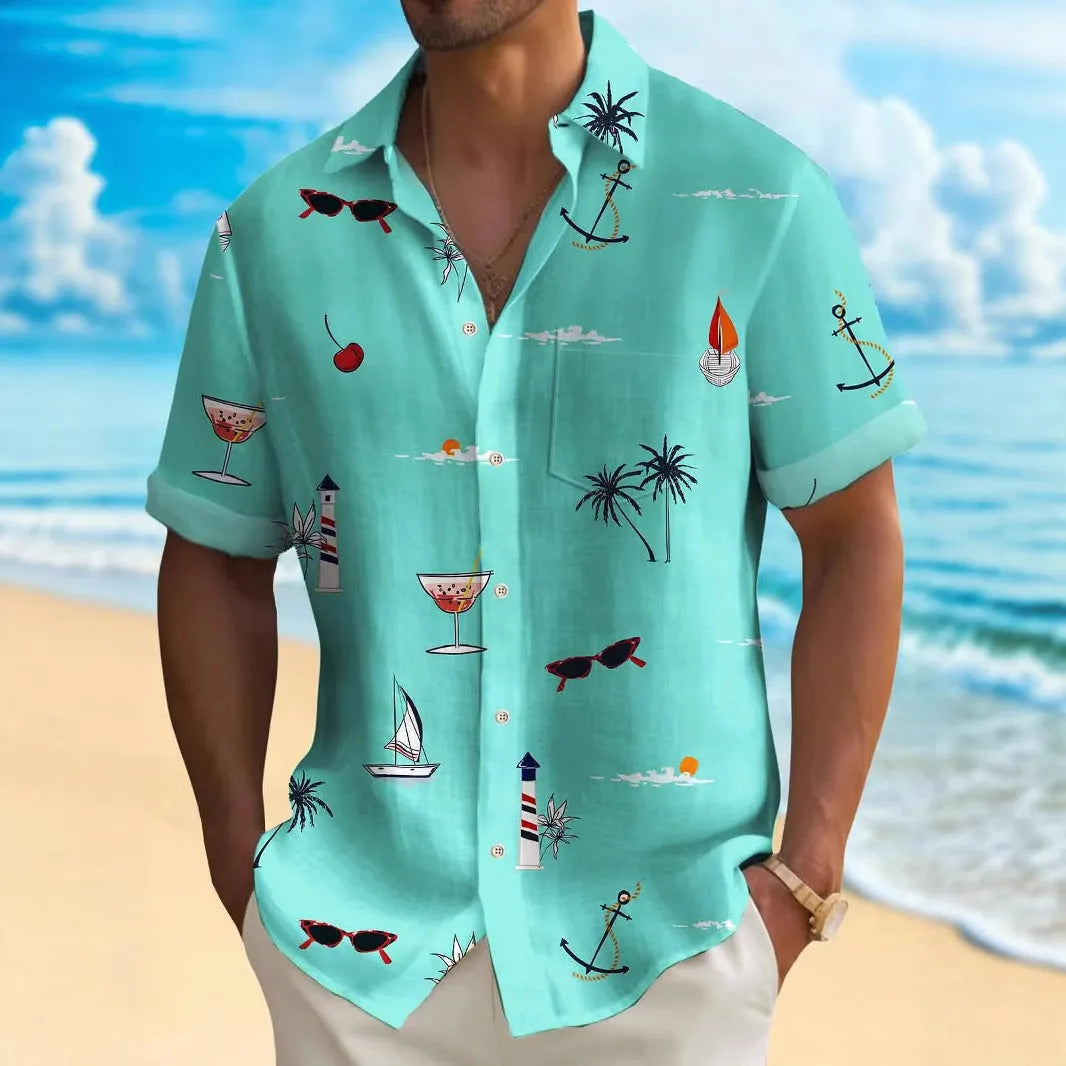 Man wearing a colourful loose-fit Hawaiian print short sleeve shirt on a beach.