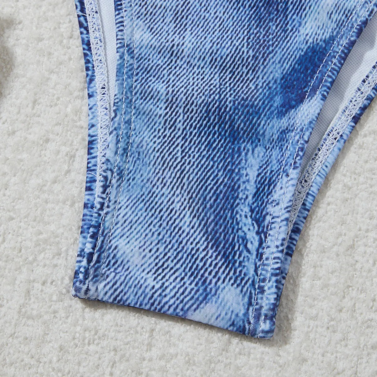 Denim blue women's bikini set with printed strap design on a hanger.