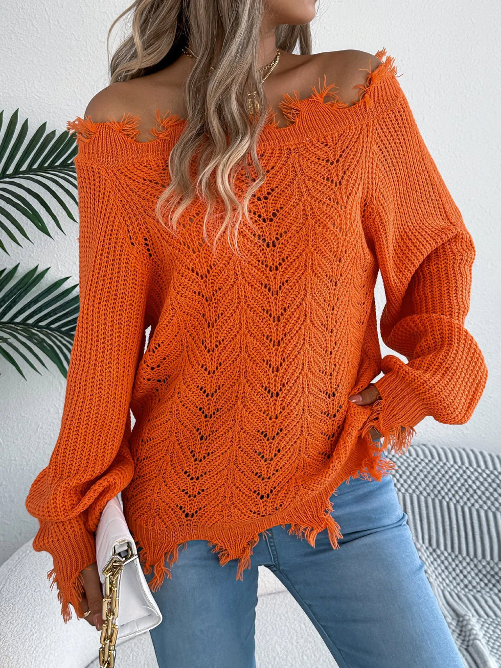 White hollow-out cut off-the-shoulder acrylic wool pullover sweater on a hanger.