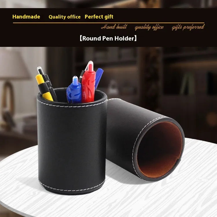 Round black leather pen container on desk holding writing instruments