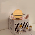 Maglev floating moon and planet night light with LED glow and small astronaut figures on base.