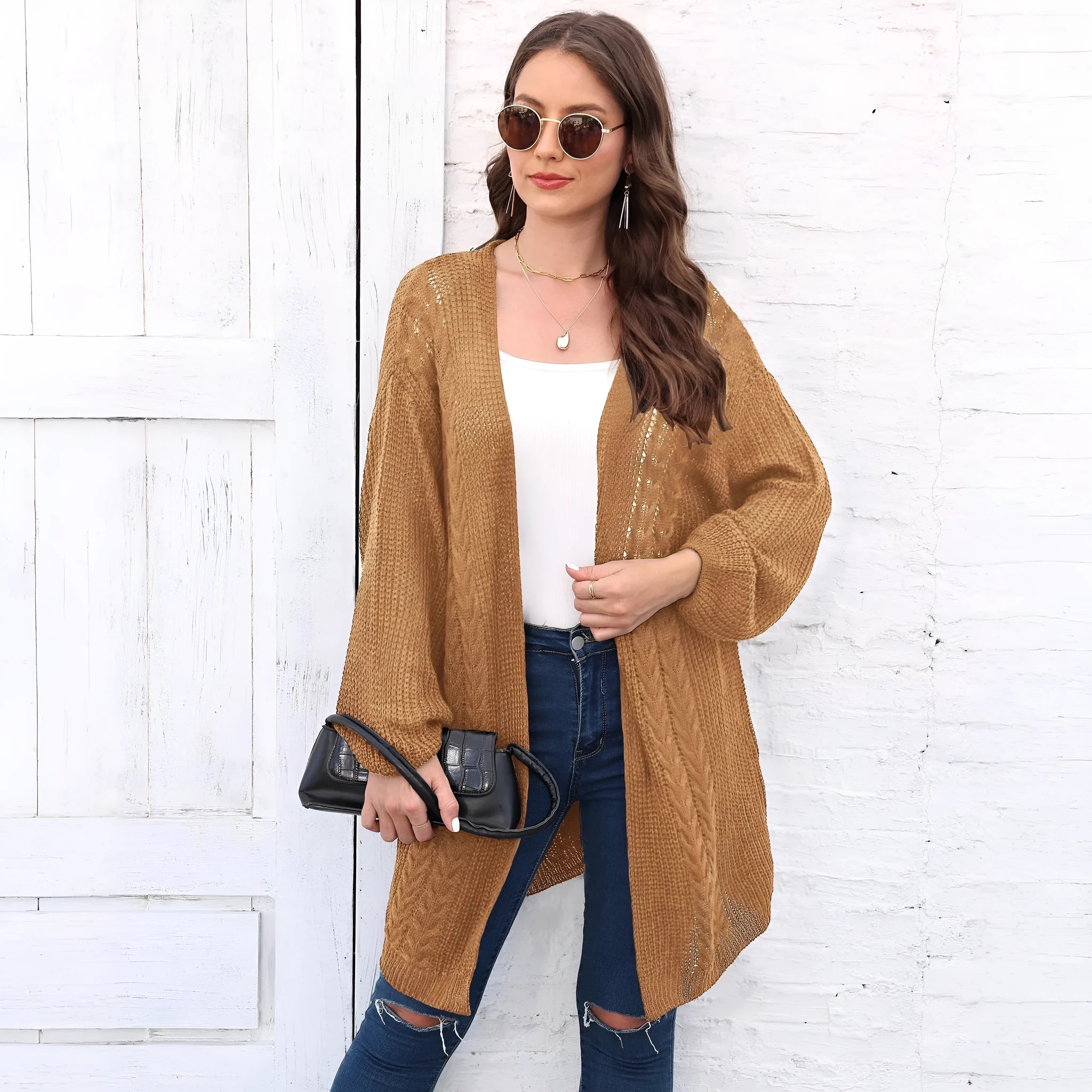 Women's loose brown acrylic sweater coat hanging, showing solid colour and knit texture.