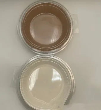 Round white disposable parchment paper liner for air fryer basket with raised edges.