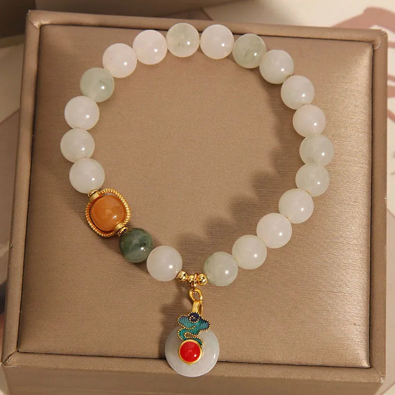 Close-up of a women's ice jade bracelet with a xiangyun peace buckle and pearl detail.