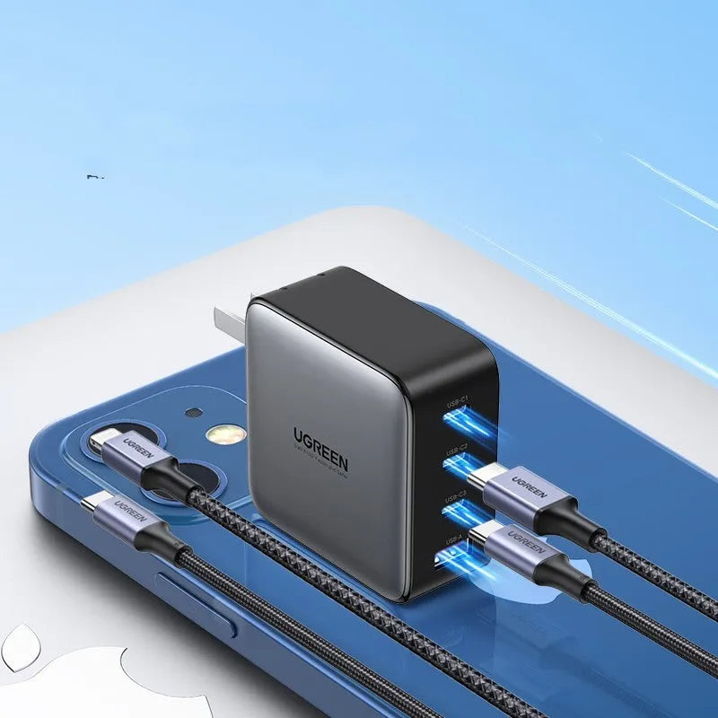 100W Gallium Nitride fast wall charger with USB-C port on a desk next to a laptop.