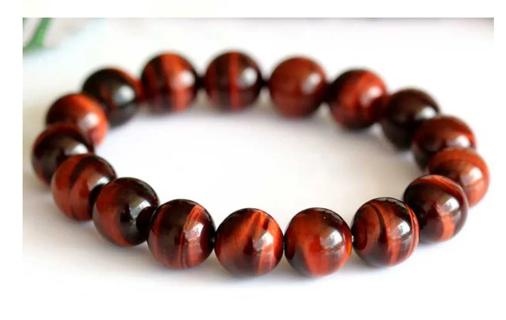 Red Tigereye wood alexandrite hand bracelet showing lightning cat's eye pattern with geometric ethnic style design