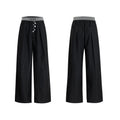 Men's black drooping straight-leg suit trousers with high waist and button detail.