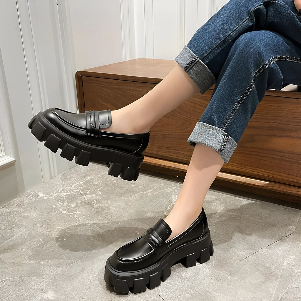 Women's wide fit patent leather loafers with a muffin heel and shallow opening on a rubber sole.