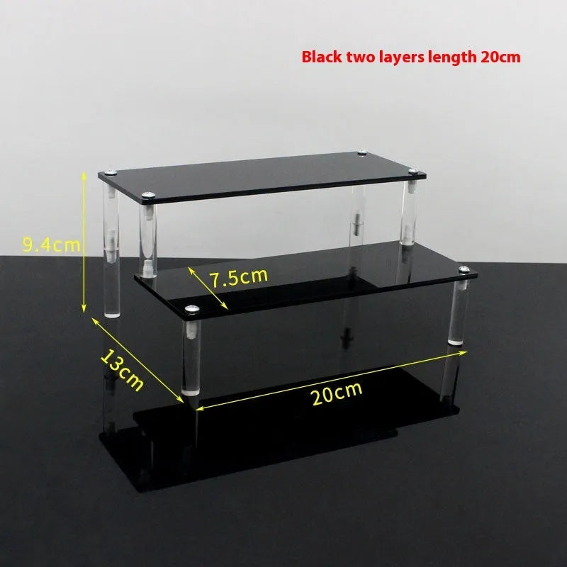 Transparent acrylic ladder display rack with three trapezoidal tiers showing blind box figurines on a desk