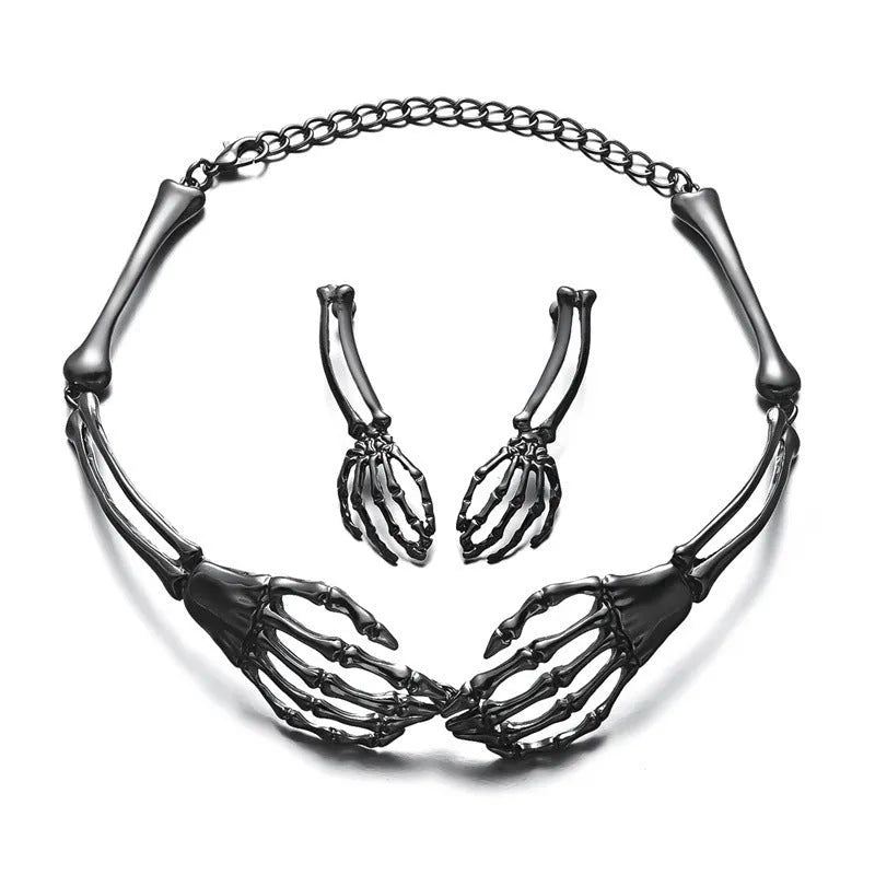 Silver alloy skull and ghost claw necklace with matching earrings set on a dark background.