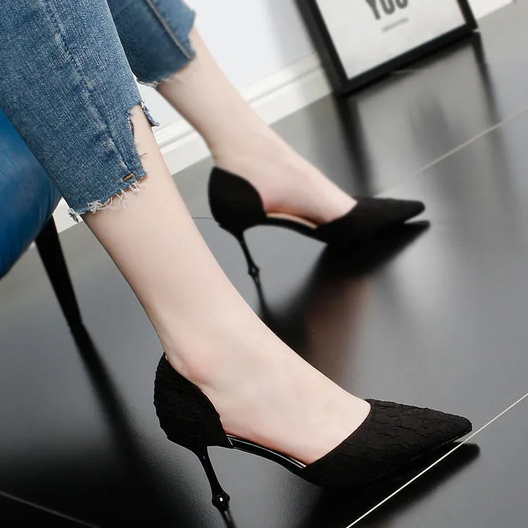 Black pointed toe stiletto high heel shoe on a white background.