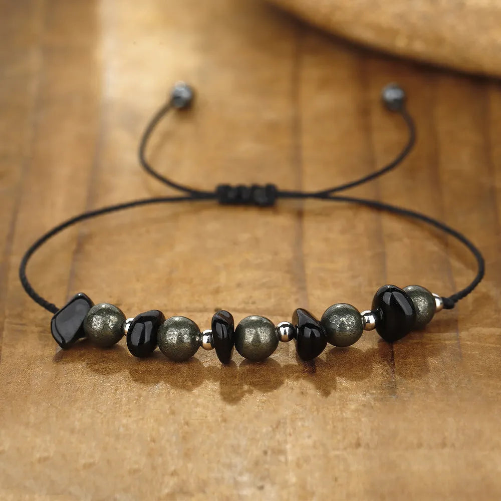 Close-up of a black garnet stone beaded bracelet with geometric design and moon charm.