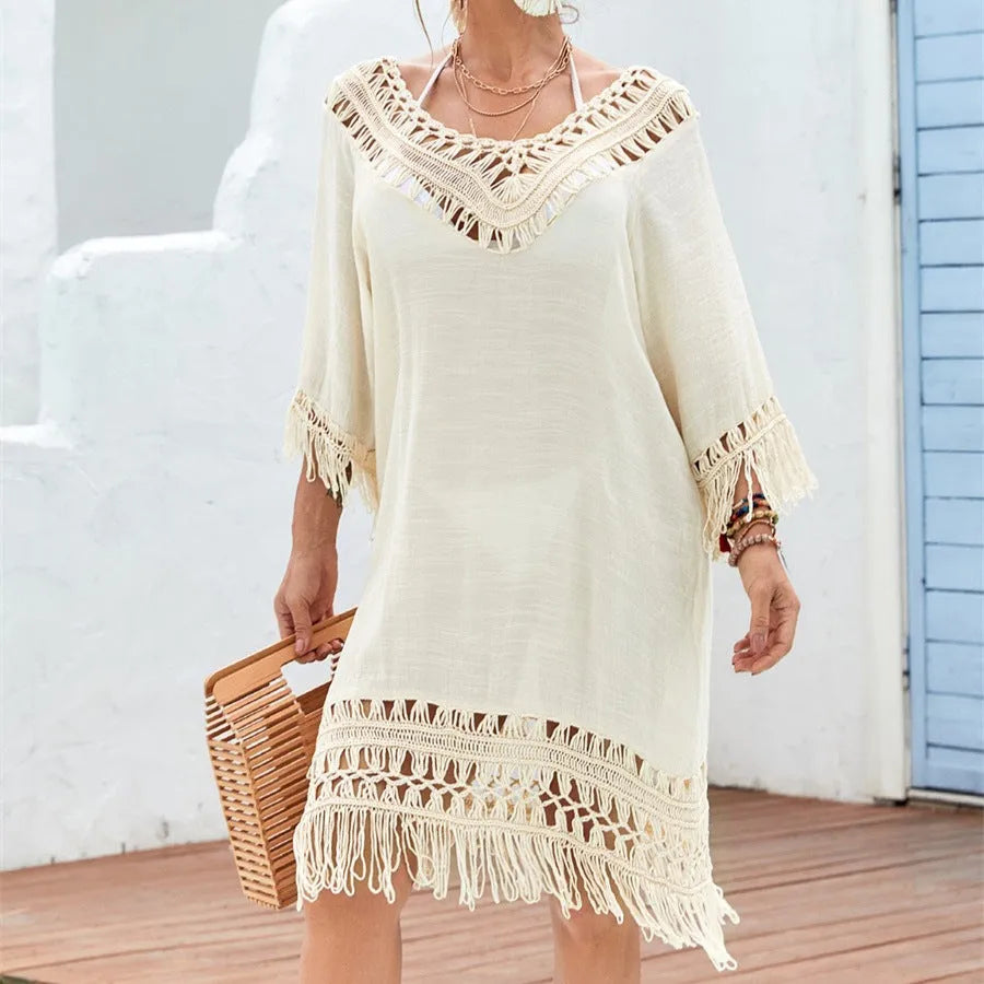 Women's apricot crocheted patchwork beach dress with half sleeves on a hanger.