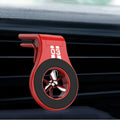 Black magnetic car air vent phone holder with adjustable ball joint and fragrance disc attached.
