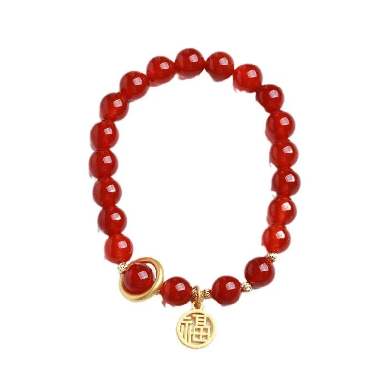 Close-up of a woven red agate bracelet showing bead detail and blessing card.