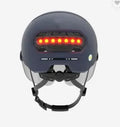 Cycling helmet with integrated red LED brake light on the back, shown in M and L sizes.