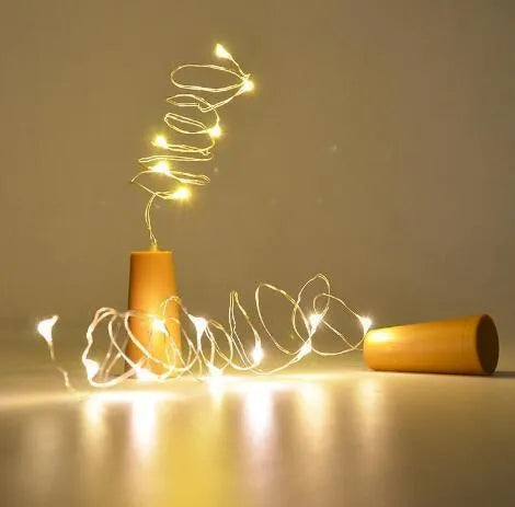 Copper wire LED string lights inserted into wine bottle with warm white illumination