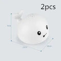 Whale-shaped electric bath toy with water spray, flashing lights, and automatic water sensing feature