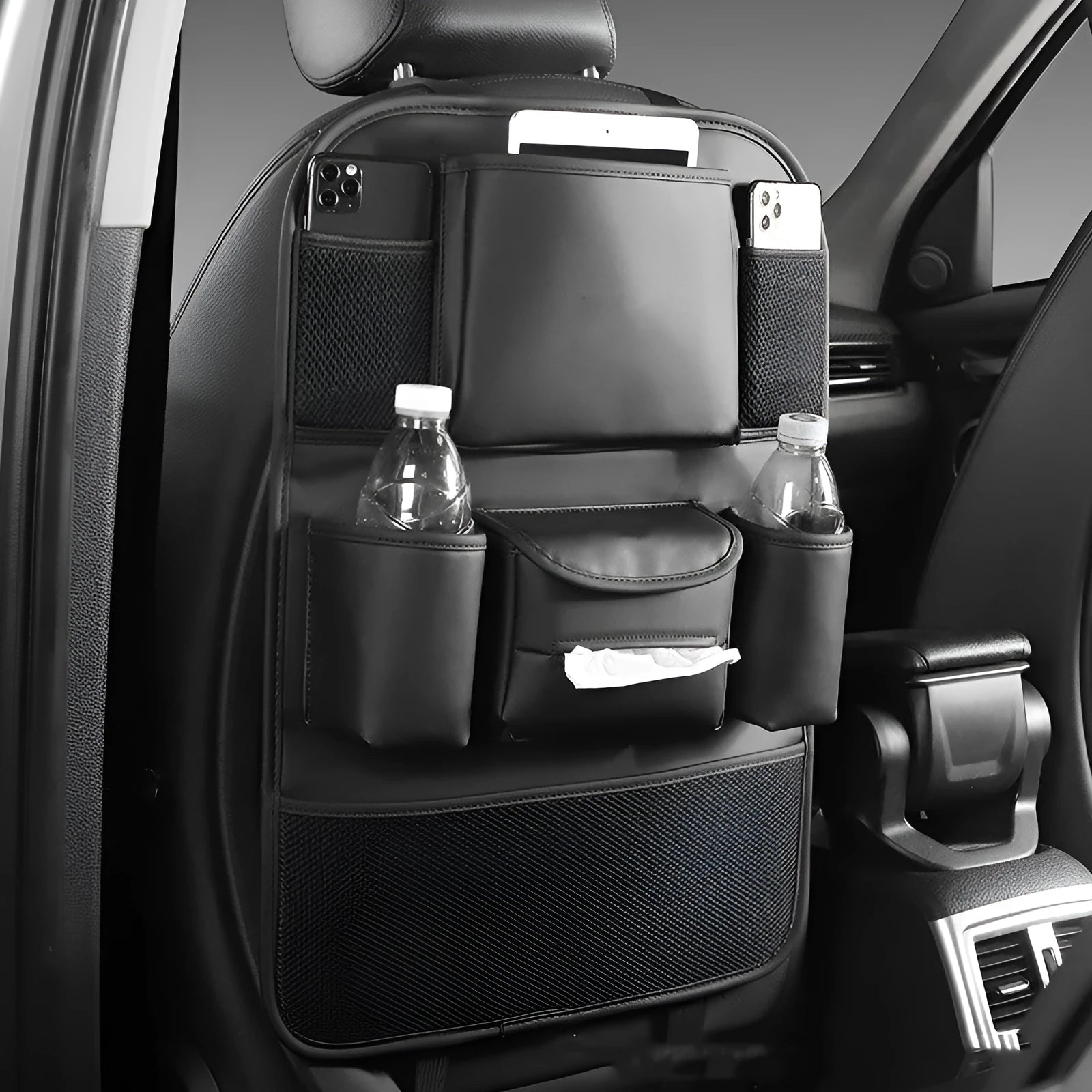 Faux leather car seat back storage organiser bag in black, shown hanging behind a car headrest.