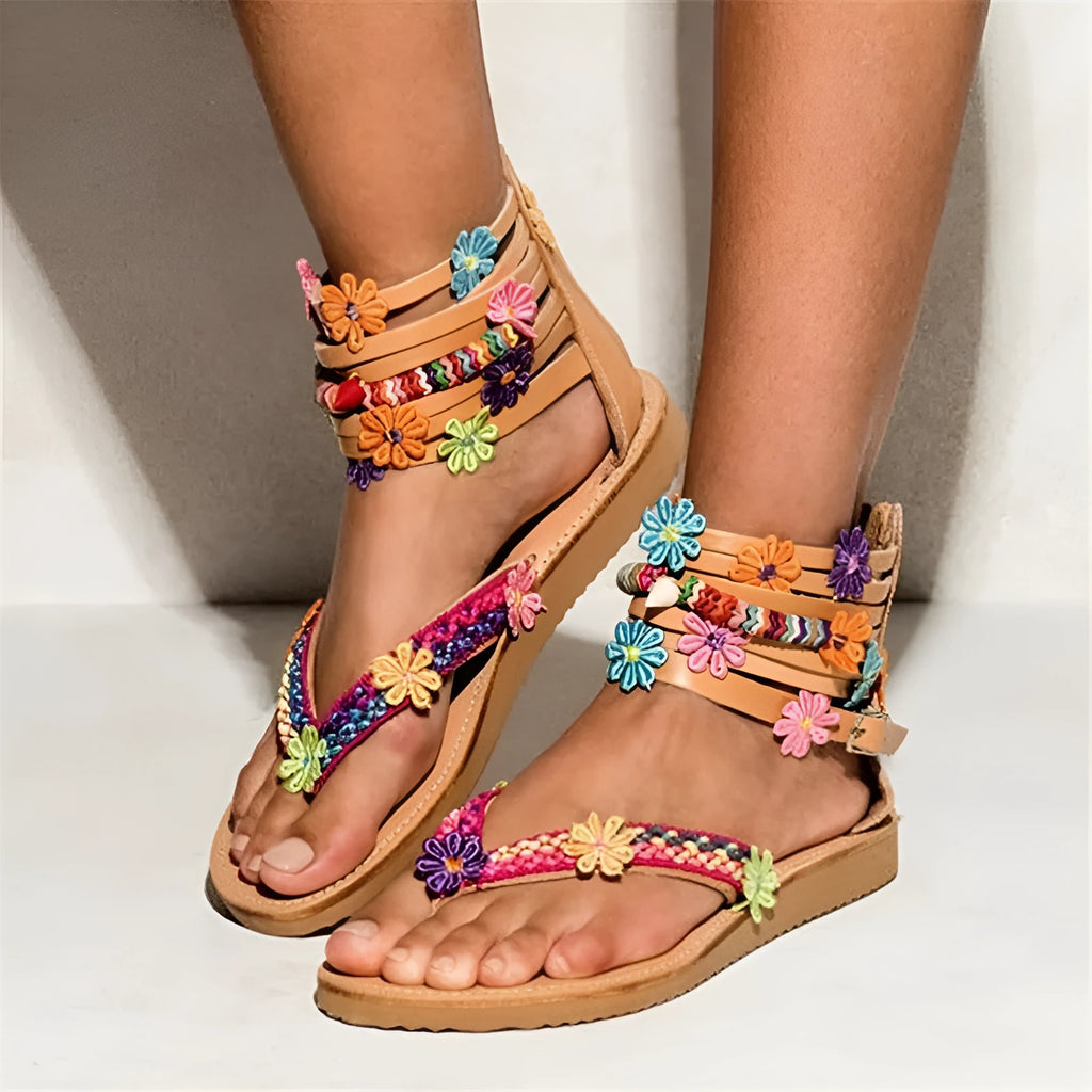 Ethnic style beaded petal sandals with floral decoration and round toe on a white background.