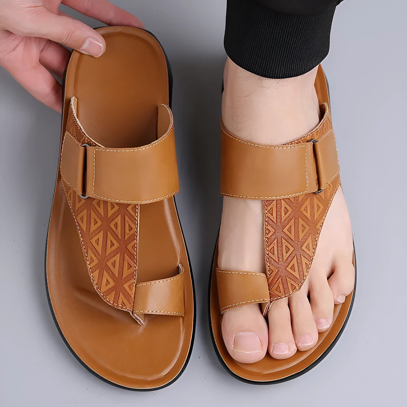 Men's light brown open-toe beach slippers made of cowhide with a rubber sole, shown on a neutral background.