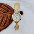 Stainless steel women's watch with round dial on wrist, showing gold colour surface and vachette clasp.