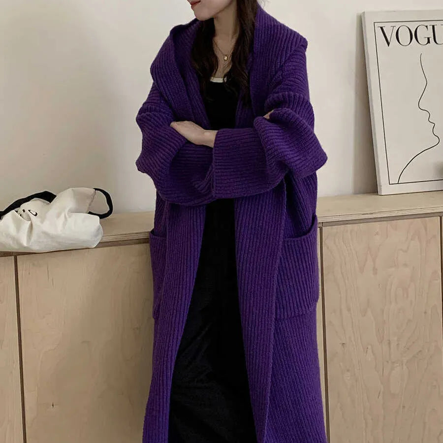 Loose grey hooded sweatshirt cardigan coat with raglan sleeves on a hanger.