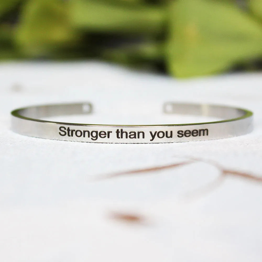 Silver customisable stainless steel bracelet with laser engraved text and adjustable fit on neutral background