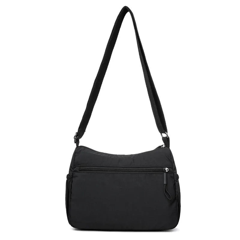 Water-repellent nylon crossbody bag with three-dimensional pockets in grey, black or red options