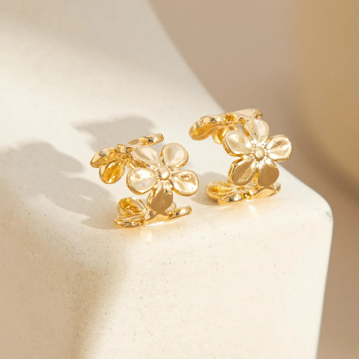 Women's gold alloy earrings with starfish and conch beach elements on post fittings
