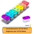 Extra large white and rainbow plastic pill organiser box with 14 removable grid compartments open on a table.