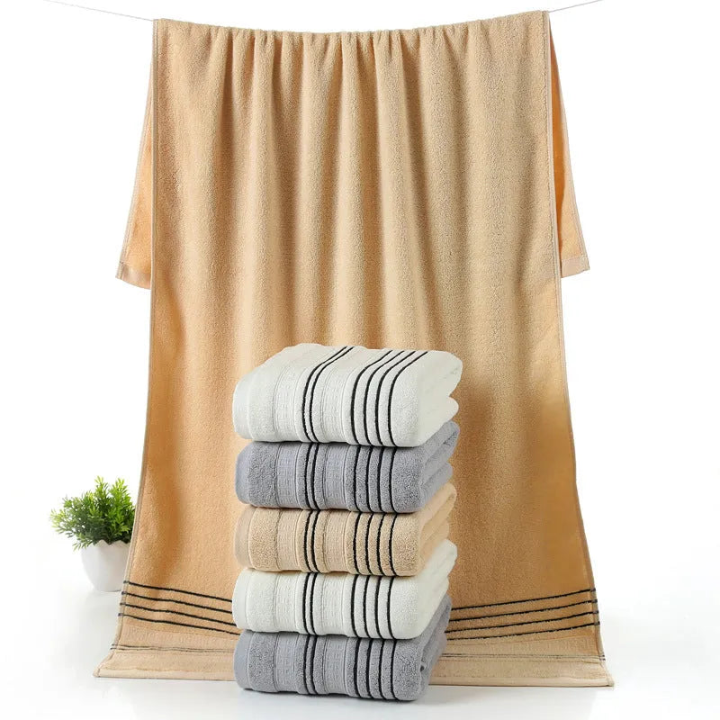 Cotton towel set showing white, grey and khaki bath towels with 34x74cm and 70x140cm dimensions