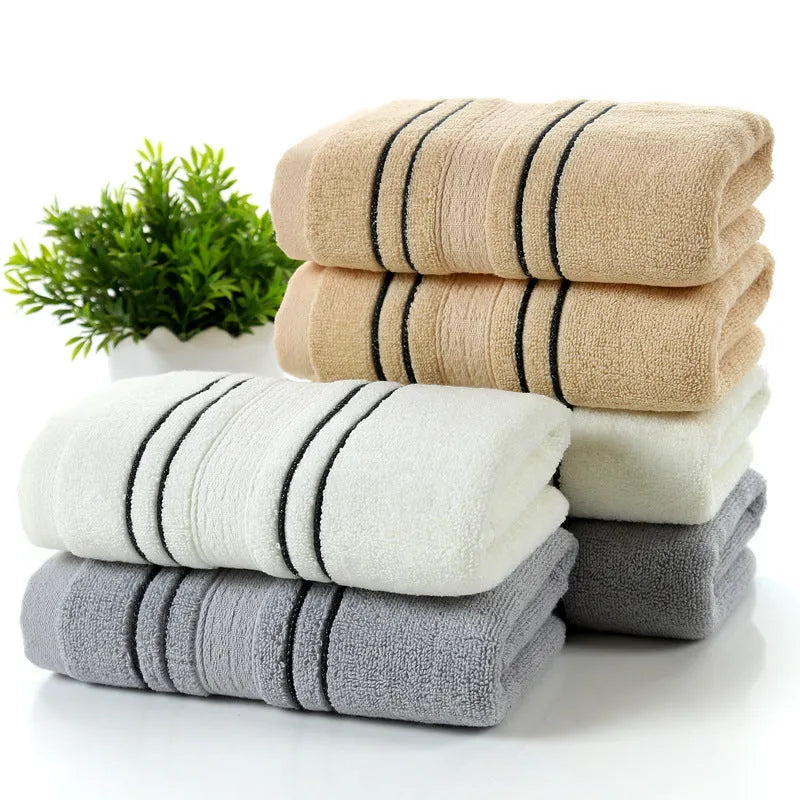 Cotton towel set showing white, grey and khaki bath towels with 34x74cm and 70x140cm dimensions