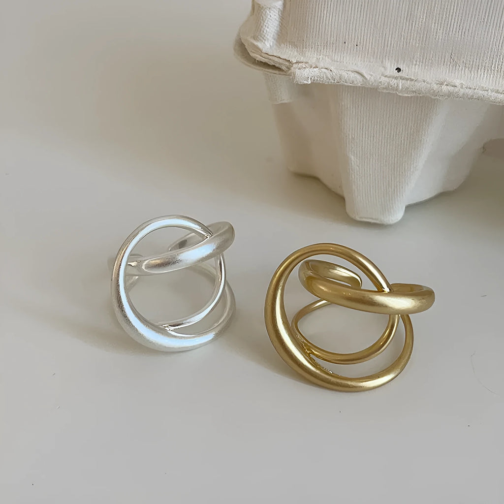 Geometric open ring with three-dimensional interlaced matte metal construction in gold or silver finish