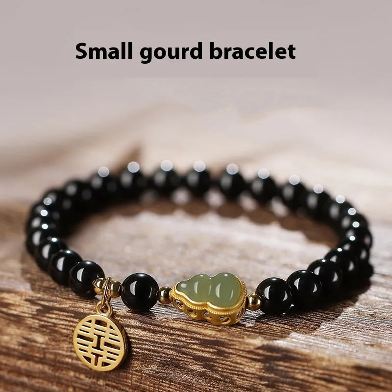 Black obsidian bracelet with a Hetian jade gourd pendant, showing geometric beads.