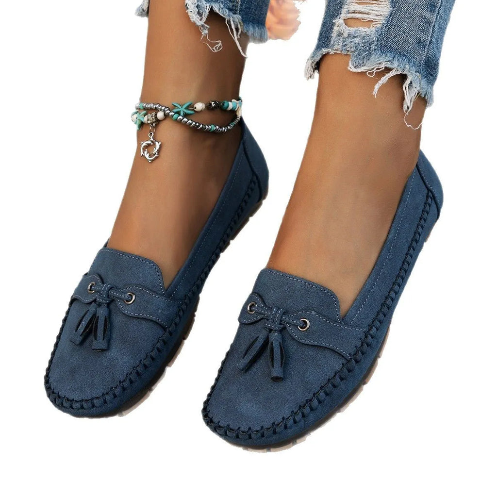 Women's suede casual flat shoes with a bow detail in pink, shown from the side.