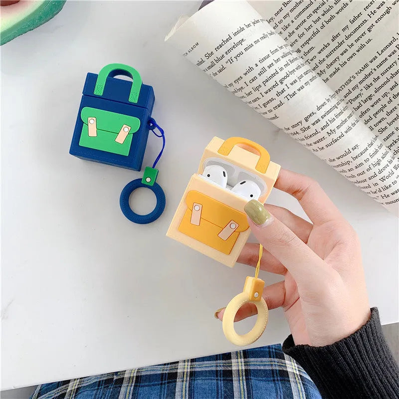 Silicone protective sleeve for AirPods 1 and 2 charging case with hanging ring, available in dark blue, green, purple, and yellow colours