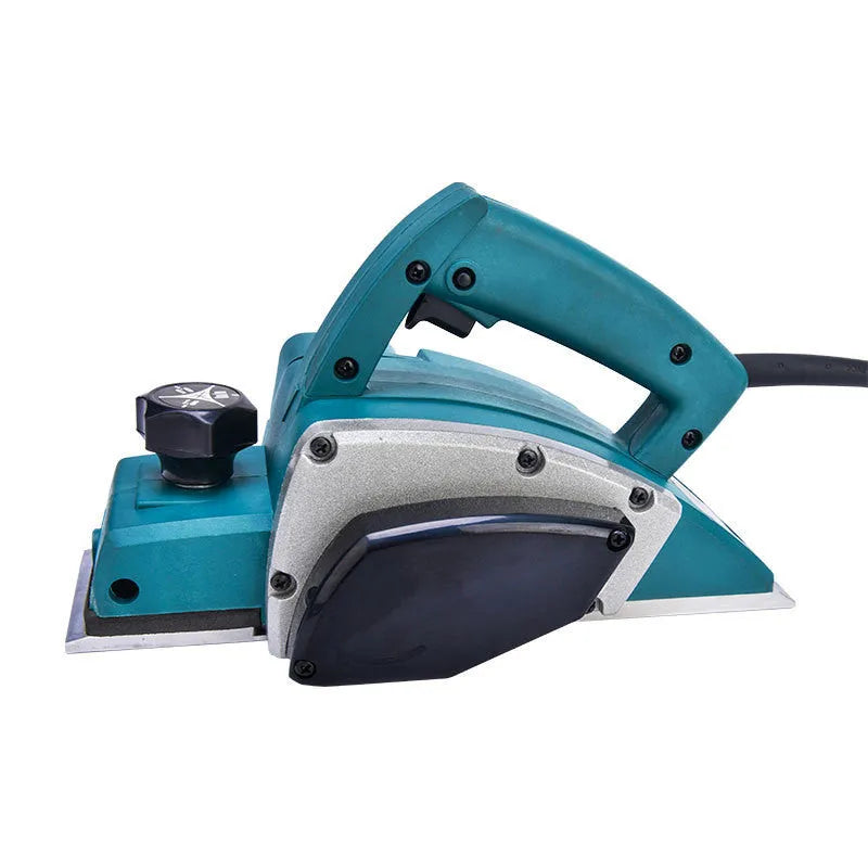 Red desktop electric wood planer with aluminium body on a workbench.