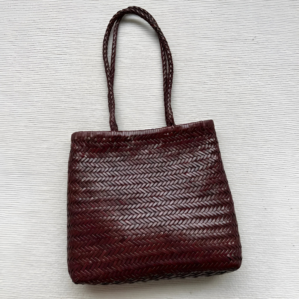 Brown woven leather tote bag with three-dimensional pocket and shoulder strap