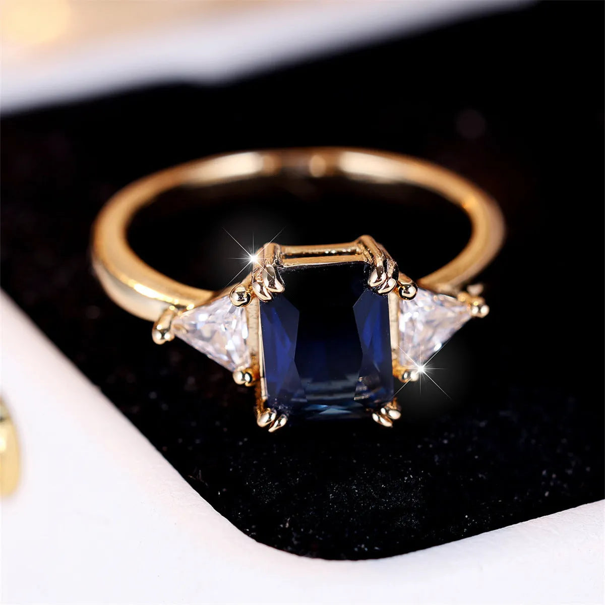 A rectangular copper fashion ring for women with a gold sapphire blue finish.
