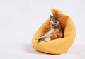 Small lazy cat figurine sitting on a sofa, a resin car dashboard ornament.