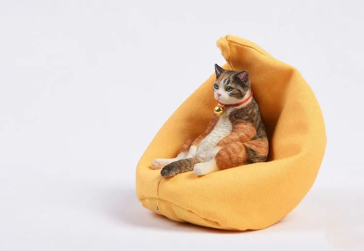 Small lazy cat figurine sitting on a sofa, a resin car dashboard ornament.