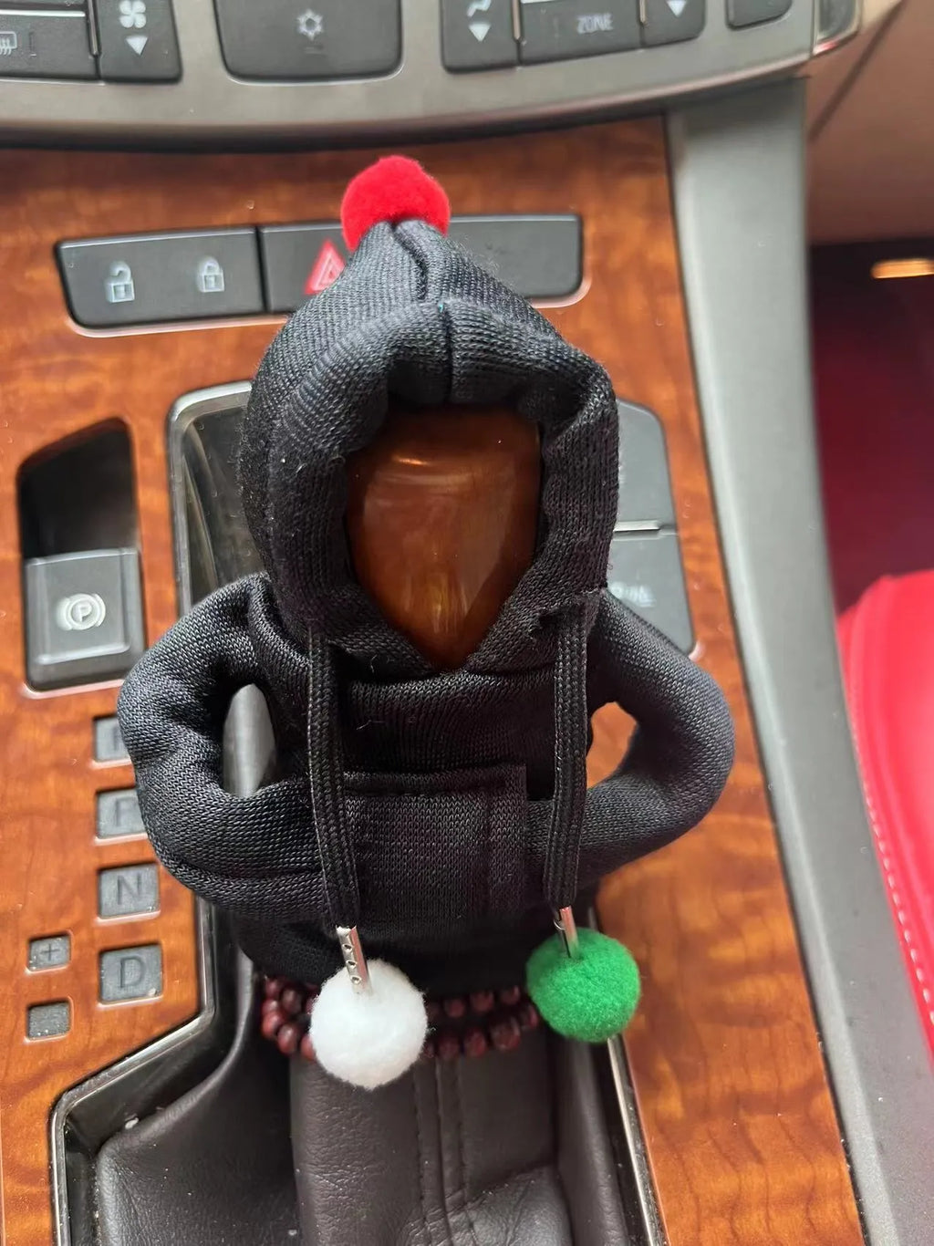 Cloth hooded sweater cover for a car gear lever in a red Christmas style.