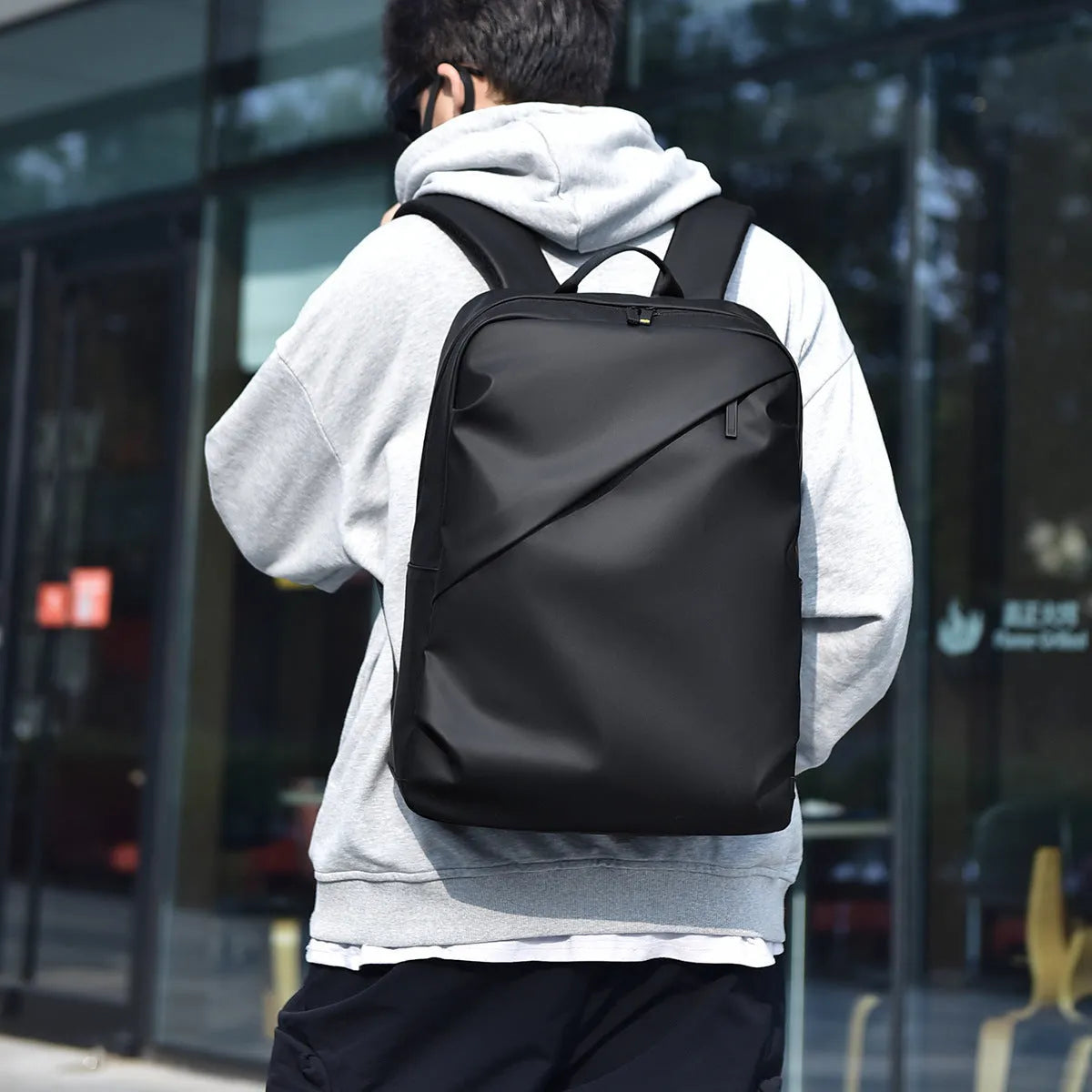 Large black waterproof PU leather backpack for men with simple design and sewing thread details.