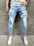 Men's denim jeans with worn-out patch detail in light blue, mid-waist tight fit British style