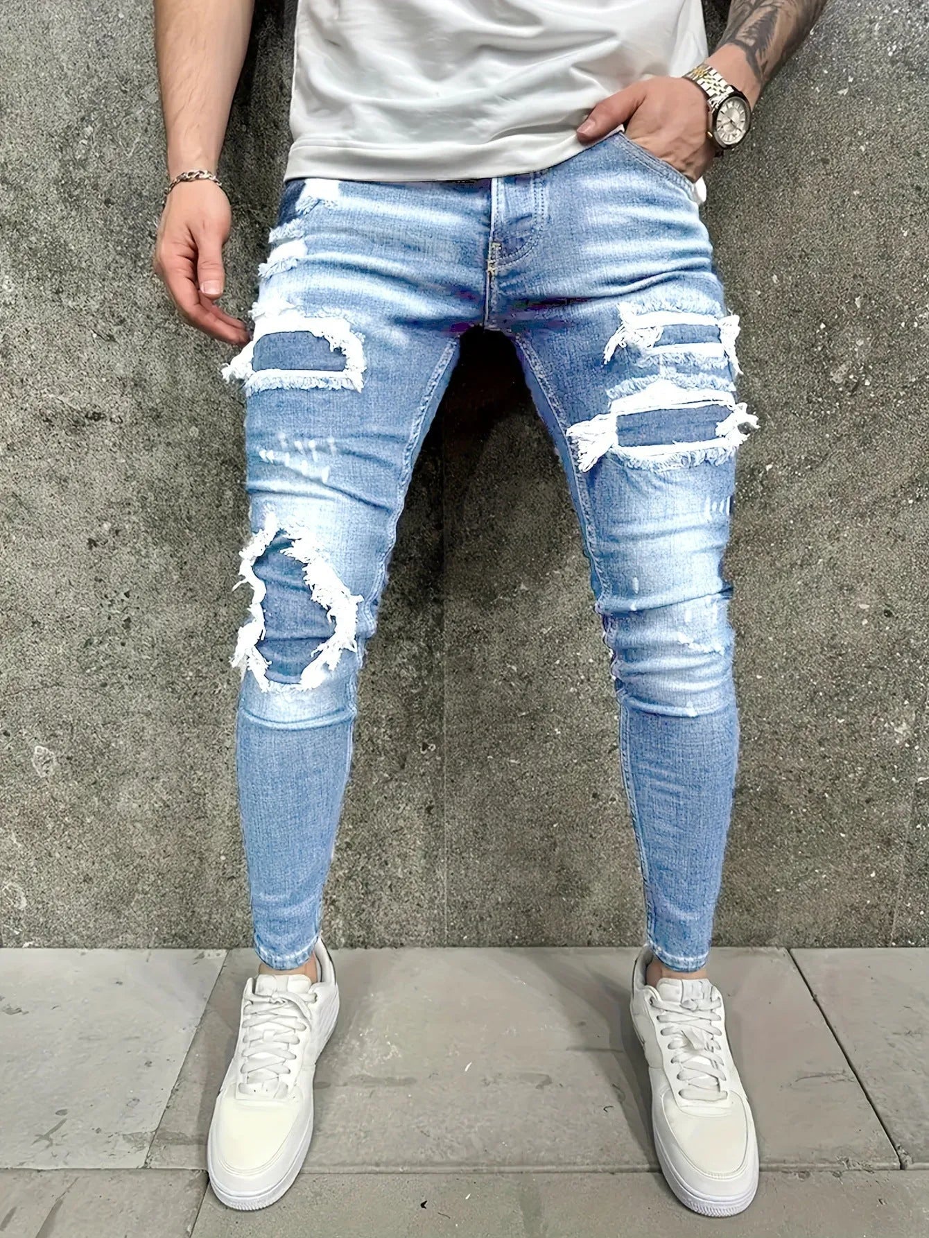 Men's denim jeans with worn-out patch detail in light blue, mid-waist tight fit British style