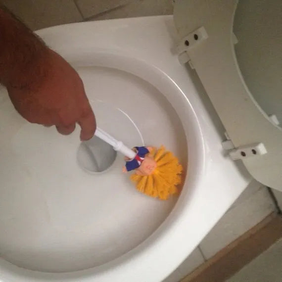 Yellow plastic Donald Trump novelty toilet brush with hanging slot.